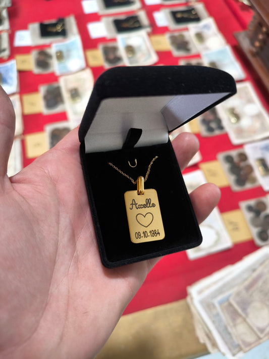 Le pendentif avec un prénom , une date de naissance et un coeur