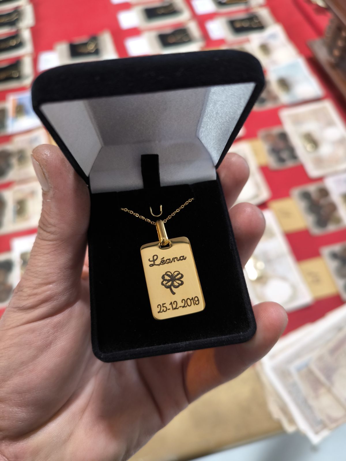 Le pendentif avec un prénom , une date de naissance et un trèfle